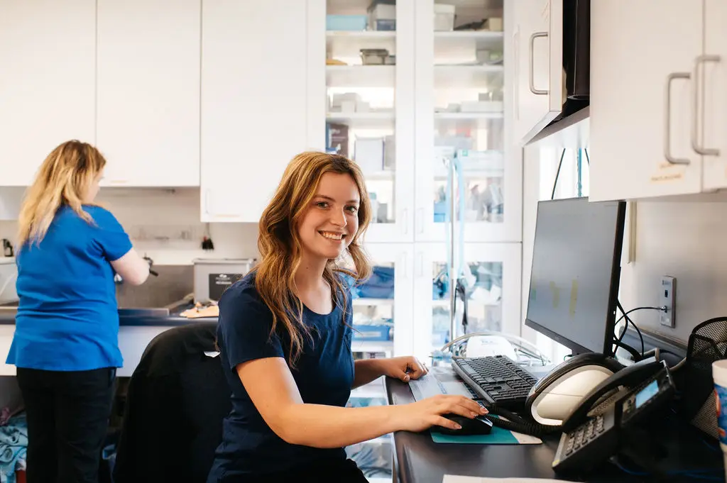 Veterinary staff works at the computer in the back of Tazewell Pike Animal Clinic.
